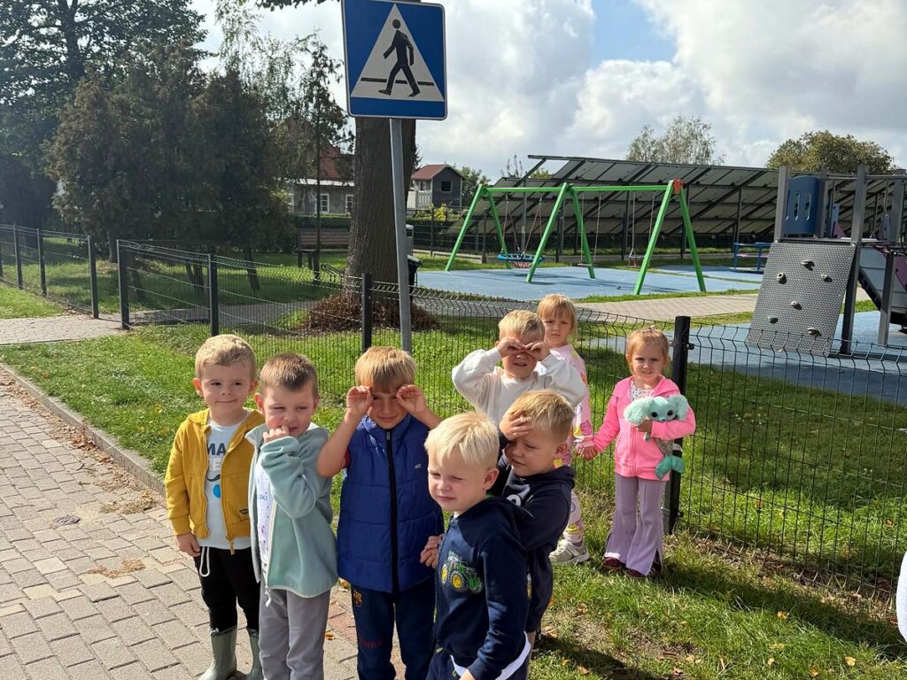 Przedszkolaki stoją przy znaku przejścia dla pieszych