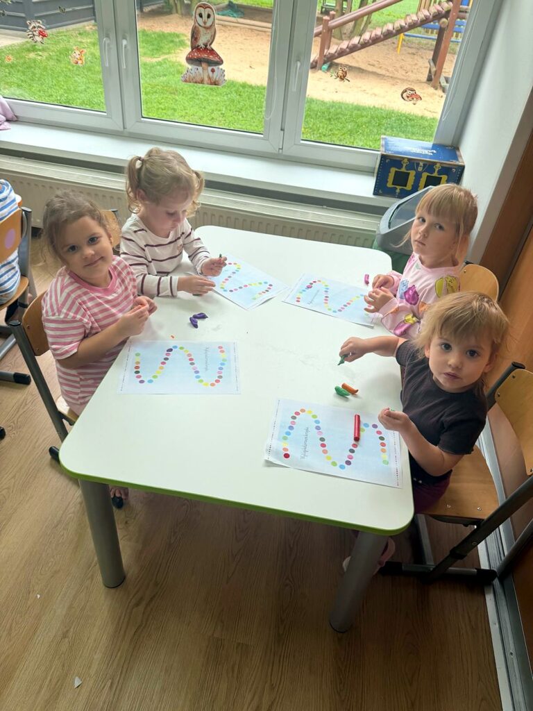 Dzieci wykonują zadania z kolorowymi kropkami