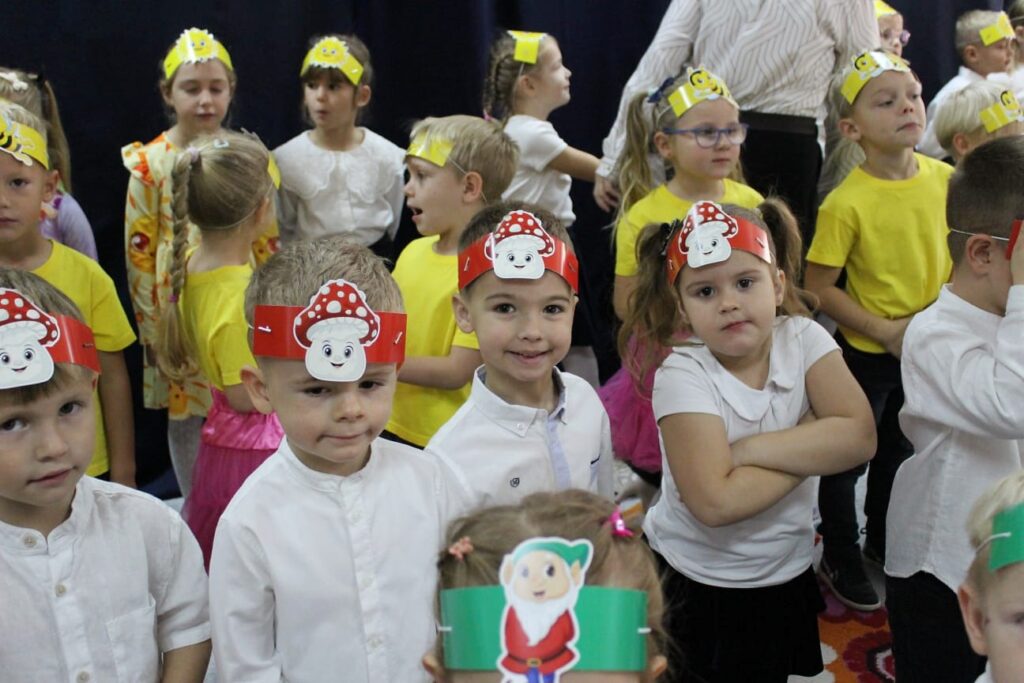 Przedszkolaki w kolorowych opaskach podczas jubileuszowego występu.