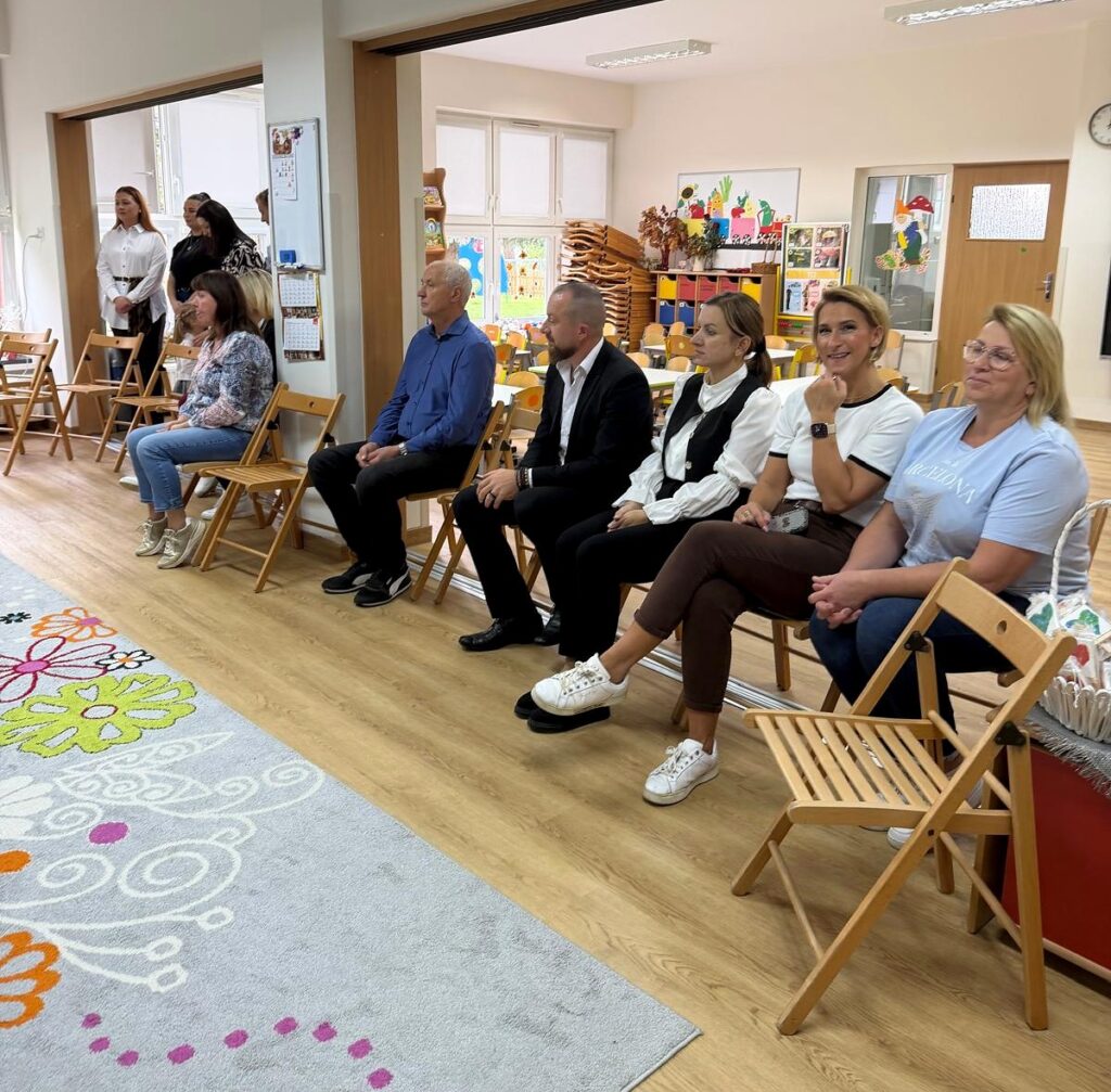 Goście uroczystości siedzą w przedszkolnej sali.